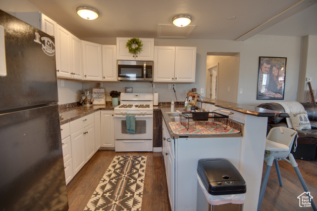 410 North Main Street Beaver, UT 84713 - Photo 15 of 31 Kitchen featuring black fridge, gas range gas stove, dark wood-type flooring, sink, and white cabinetry