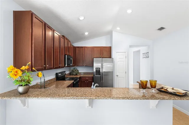 a kitchen with granite countertop cabinets and refrigerator