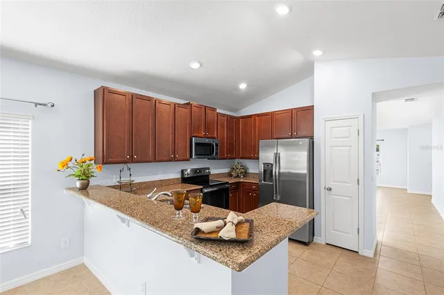a kitchen with stainless steel appliances granite countertop a stove sink and cabinets