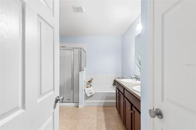 a bathroom with a granite countertop sink a large mirror and a bathtub with shower
