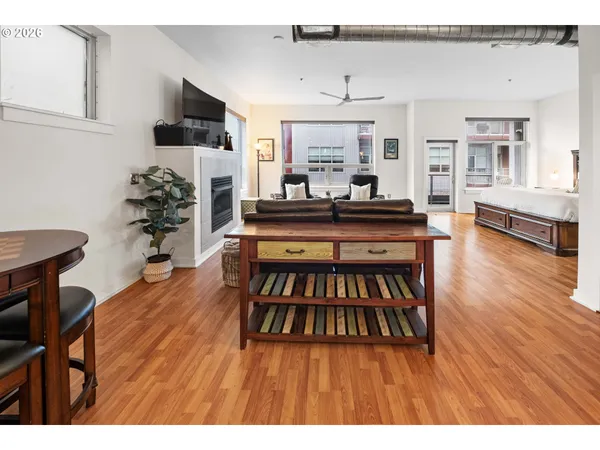 a living room with furniture wooden floor and a kitchen view