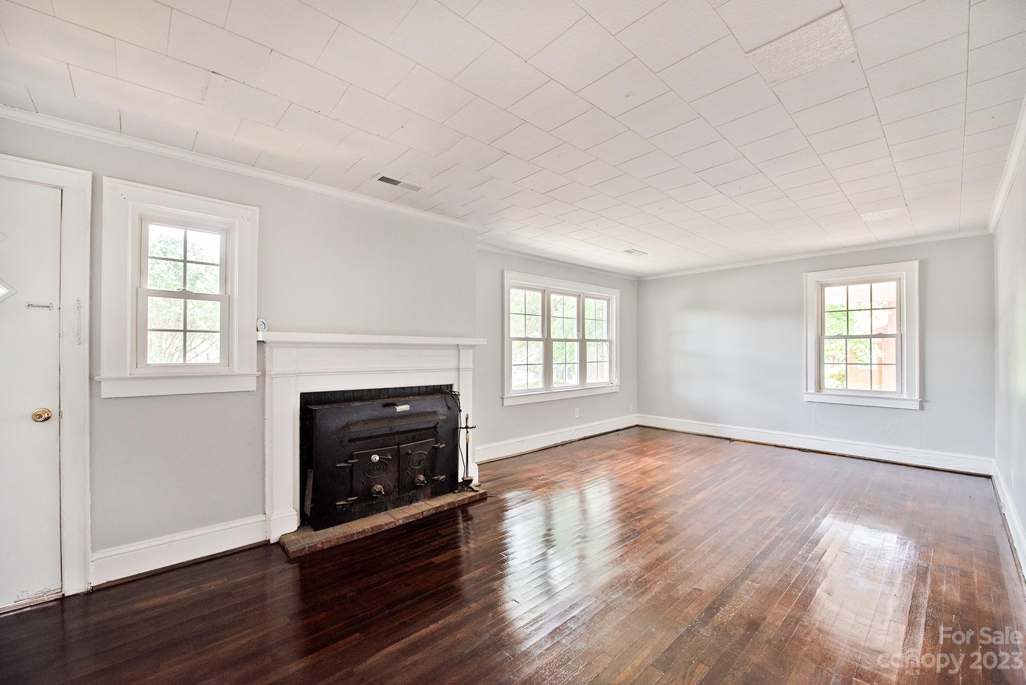 366 South Main Street Rutherfordton, NC 28139 - Photo 4 of 22 an empty room with wooden floor fireplace and windows
