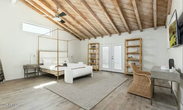 a spacious bedroom with a bed and a flat screen tv