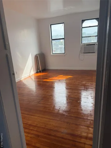 a view of room with window and wooden floor