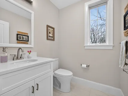 a bathroom with a toilet sink vanity and mirror