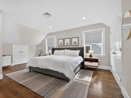 a spacious bedroom with a bed and a night stand