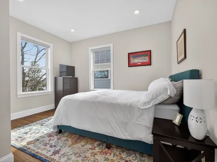 a bedroom with a bed and wooden floor