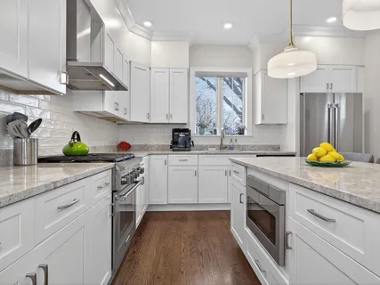 a kitchen with stainless steel appliances granite countertop a sink a stove and cabinets