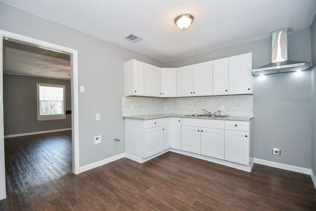 7334 Mountbatten Road Houston, TX 77033 - Photo 9 of 28 Another view of the kitchen showcasing abundant cabinetry, ample prep space, and an open connection to the living area.