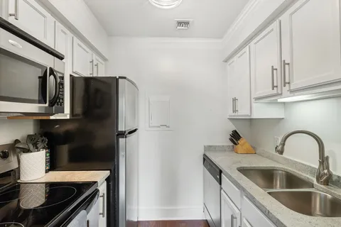 a kitchen with stainless steel appliances granite countertop a refrigerator sink and stove