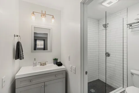 a bathroom with a shower sink and mirror