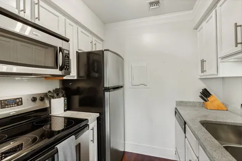 a kitchen with stainless steel appliances granite countertop a refrigerator and a stove
