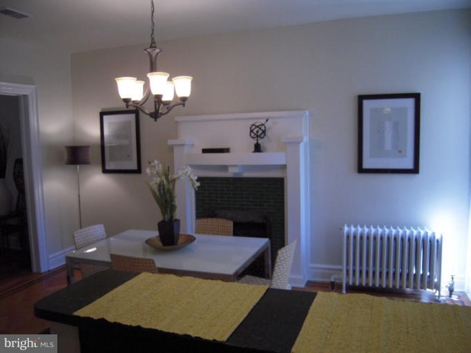 1346 Spring Road Northwest Washington, DC 20010 - Photo 16 of 30 a living room with furniture a chandelier and a fireplace