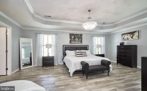 2301 Harmsworth Drive Dumfries, VA 22026 - Photo 7 of 18 a bedroom with a large bed and a chandelier