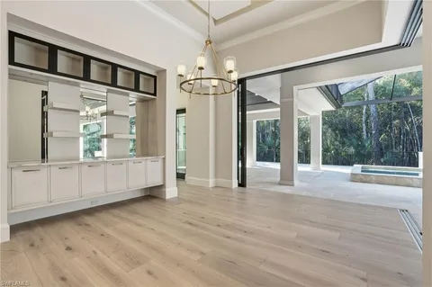 a large kitchen with kitchen island a stove a sink a refrigerator and white cabinets