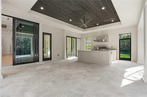 a view of a hallway with wooden floor and a glass door shower