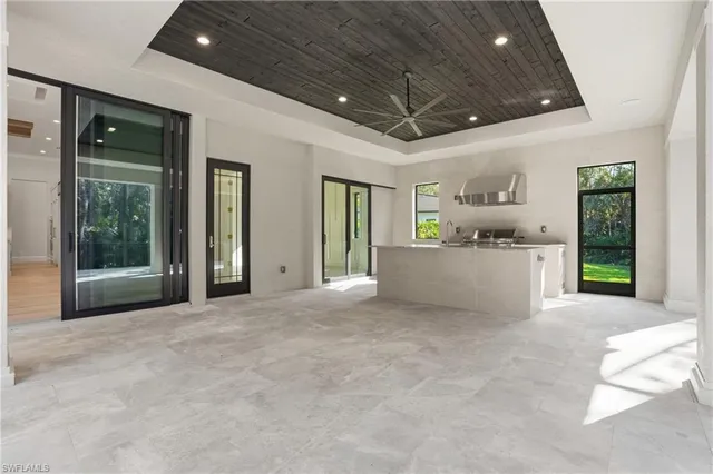 a view of a hallway with wooden floor and a glass door shower