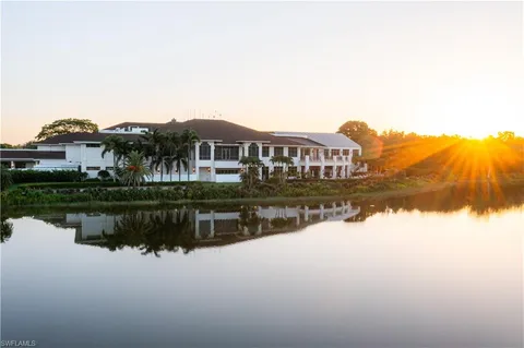a view of a house with a yard and a pond