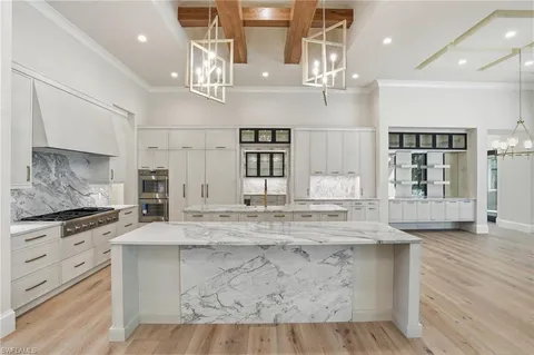 a kitchen with kitchen island granite countertop a stove and a wooden floors