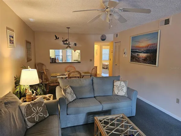 a living room with furniture a flat screen tv and a large window