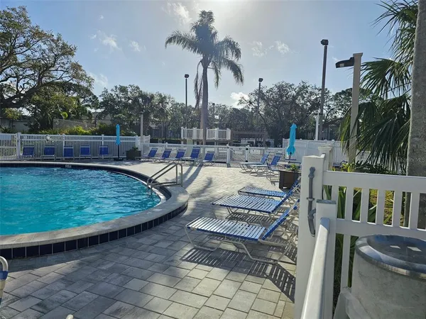 a front view of a house with swimming pool and furniture