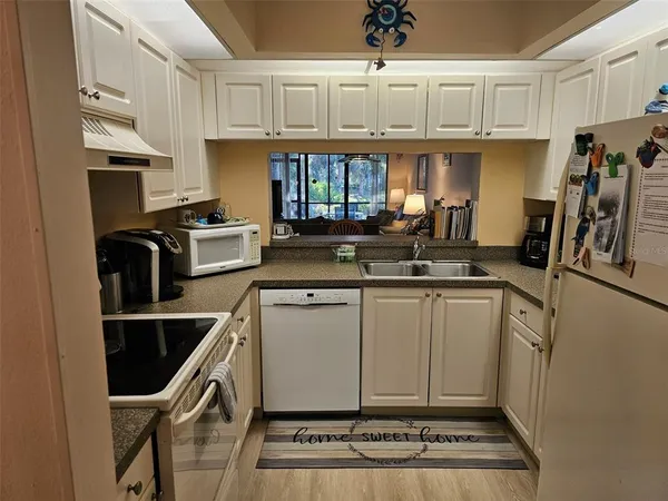 a kitchen with granite countertop a sink stainless steel appliances and cabinets