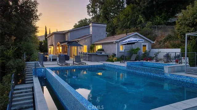 a view of a house with pool and chairs