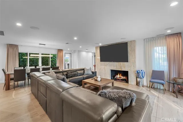 a living room with furniture fireplace and a large window