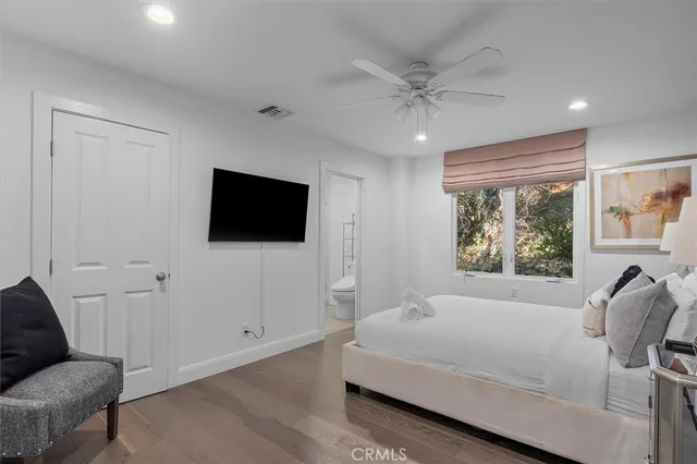 a spacious bedroom with a bed and a flat screen tv