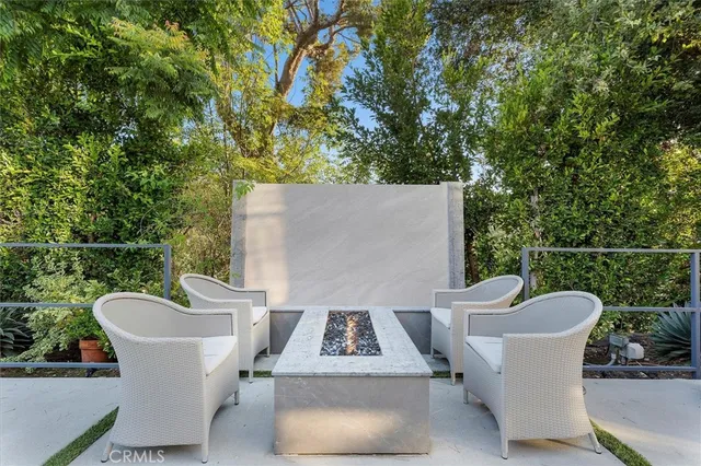 a view of a patio with a table and chairs and a barbeque