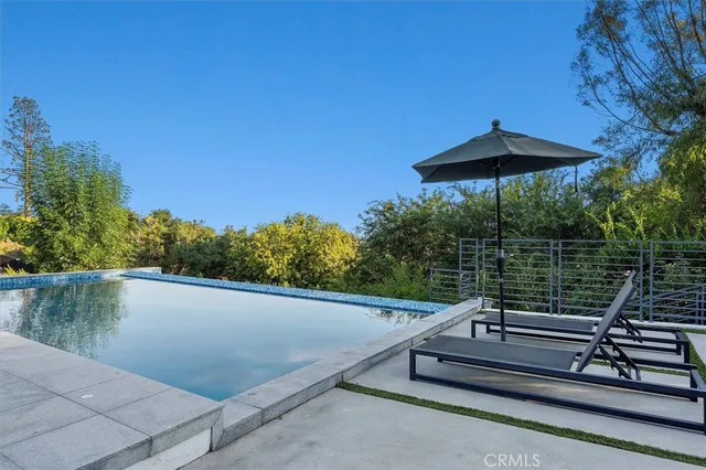 a view of a patio with a table and chairs under an umbrella