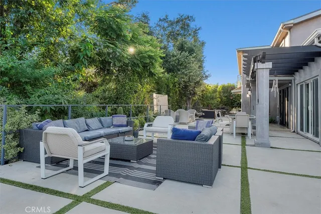 a view of a patio with couches and a table and chairs with wooden fence