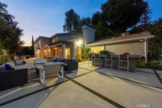 a view of a patio with couches table and chairs and potted plants