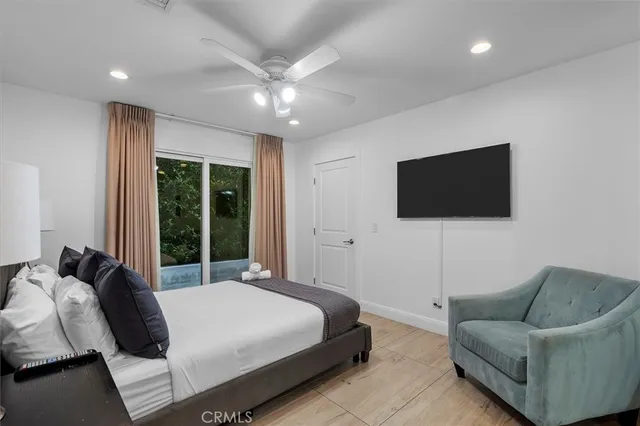 a bedroom with a bed a couch and a flat tv screen