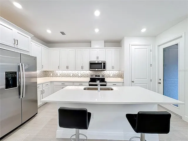 a kitchen with white cabinets and white appliances