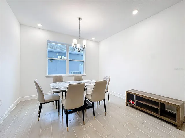 a view of a dining room with furniture a chandelier and wooden floor