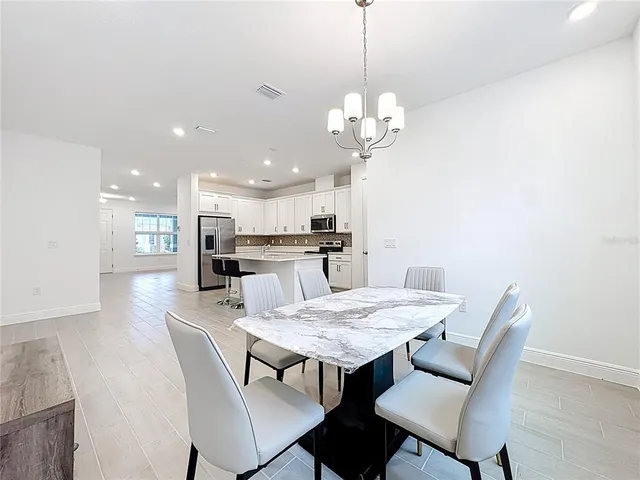 a view of a dining room with a table and chairs