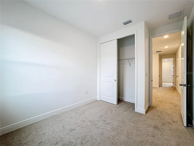 an empty room with closet and a bathroom