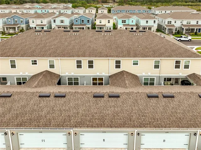 an aerial view of residential houses with outdoor space and ocean view