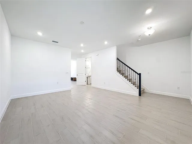 a view of a hallway with wooden floor and entryway