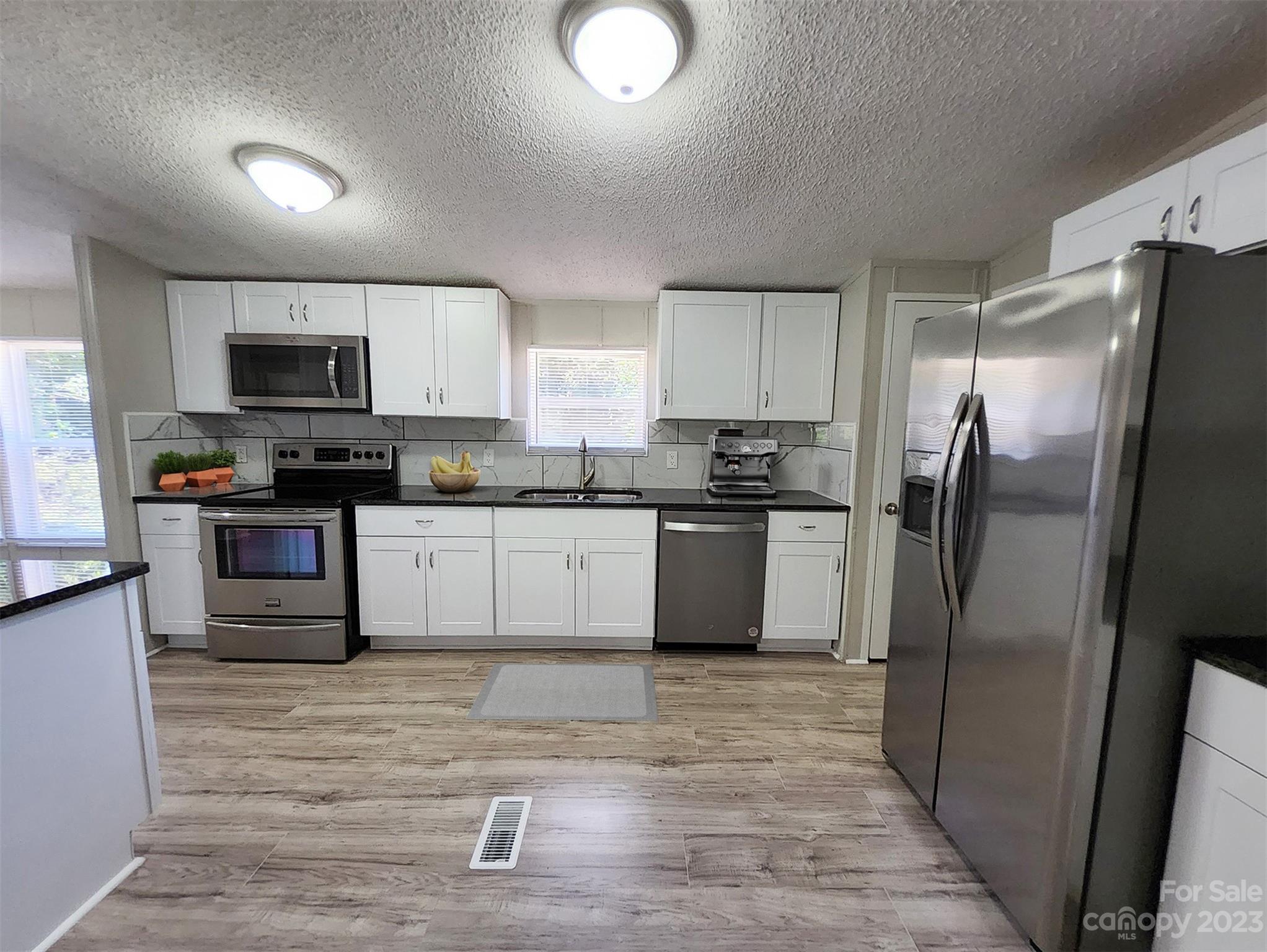 415 Maple Creek Road Rutherfordton, NC 28139 - Photo 4 of 10 a kitchen with stainless steel appliances granite countertop a refrigerator sink and microwave