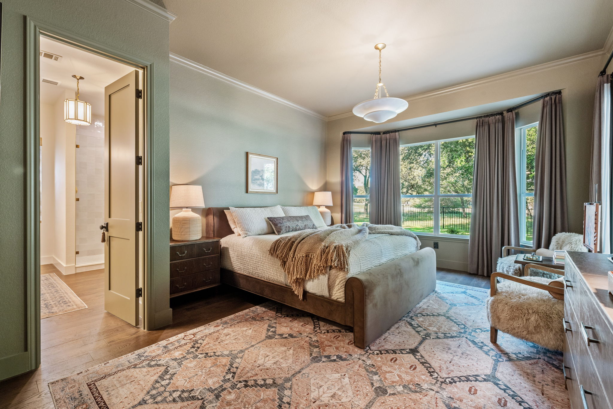 118 Cold Springs Drive Georgetown, TX 78633 - Photo 23 of 40 A tranquil primary bedroom suite with large windows offers peaceful outdoor views and seamless access to a well-appointed private bath.