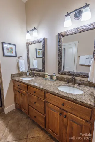 a bathroom with a granite countertop sink two large mirror and a