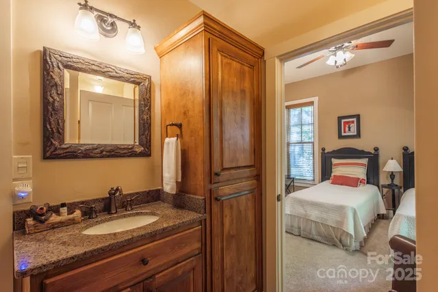 a en suite bathroom with a granite countertop sink and a mirror