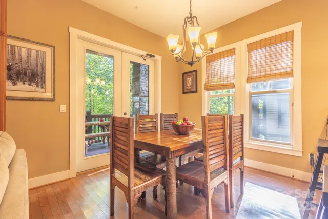 a dining room with furniture a chandelier and wooden floor