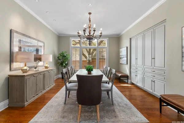 a dining room with chandelier and wooden floor