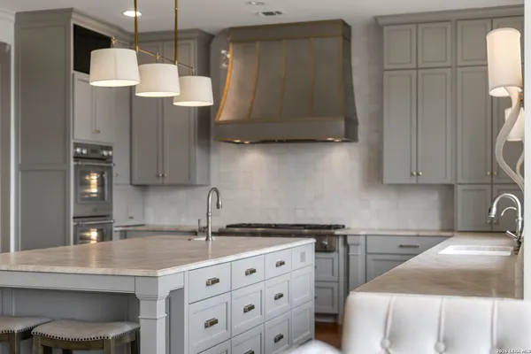 a kitchen with stainless steel appliances granite countertop a sink a stove and a refrigerator with wooden floor