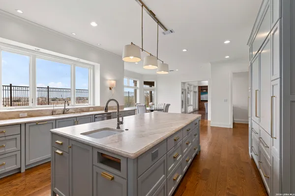 a large kitchen with kitchen island a large counter space appliances and a sink