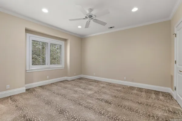 an empty room with windows and ceiling fan