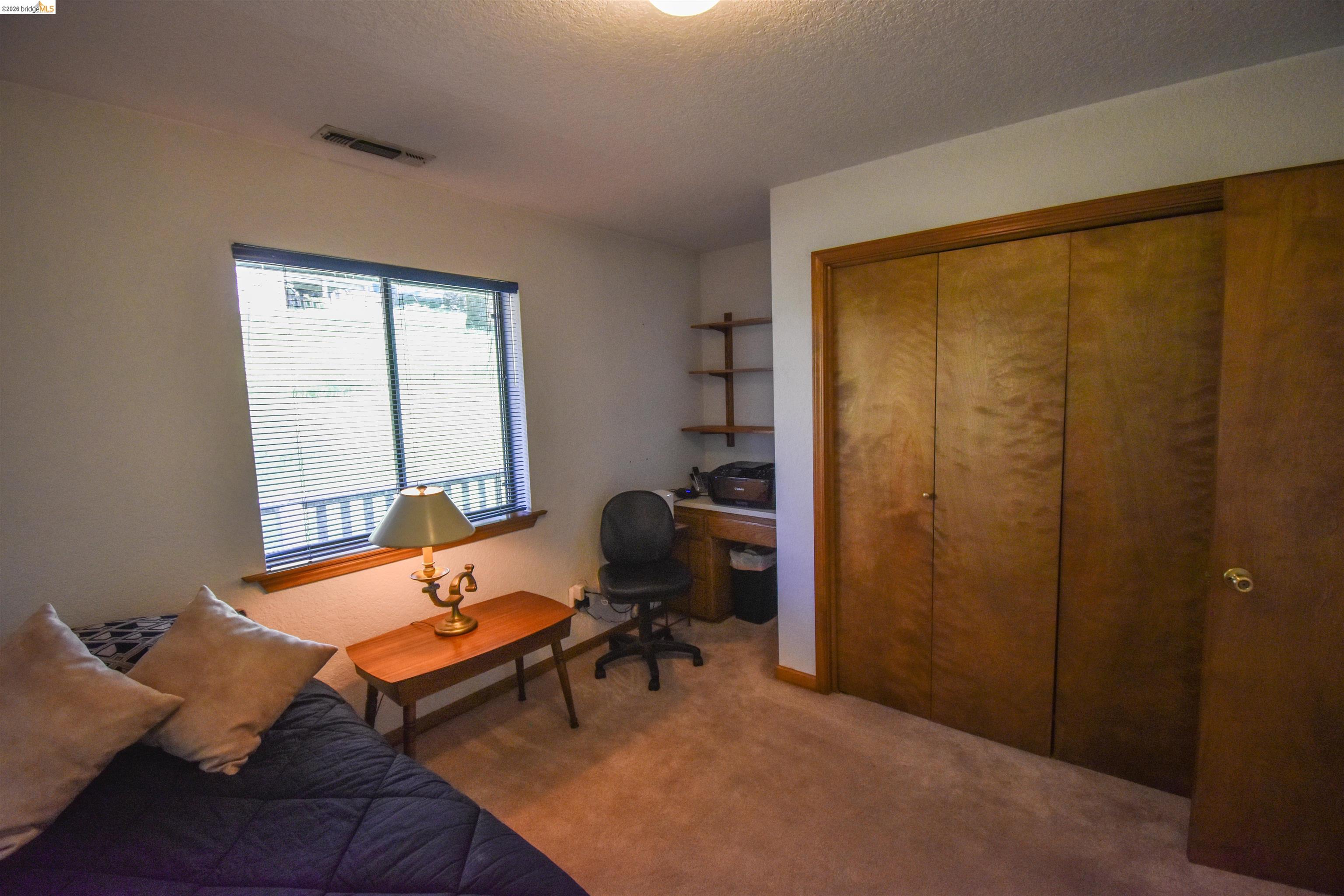 15170 Potato Ranch Road Sonora, CA 95370 - Photo 25 of 49 Bedroom featuring carpet floors, a desk, a closet, and a textured ceiling
